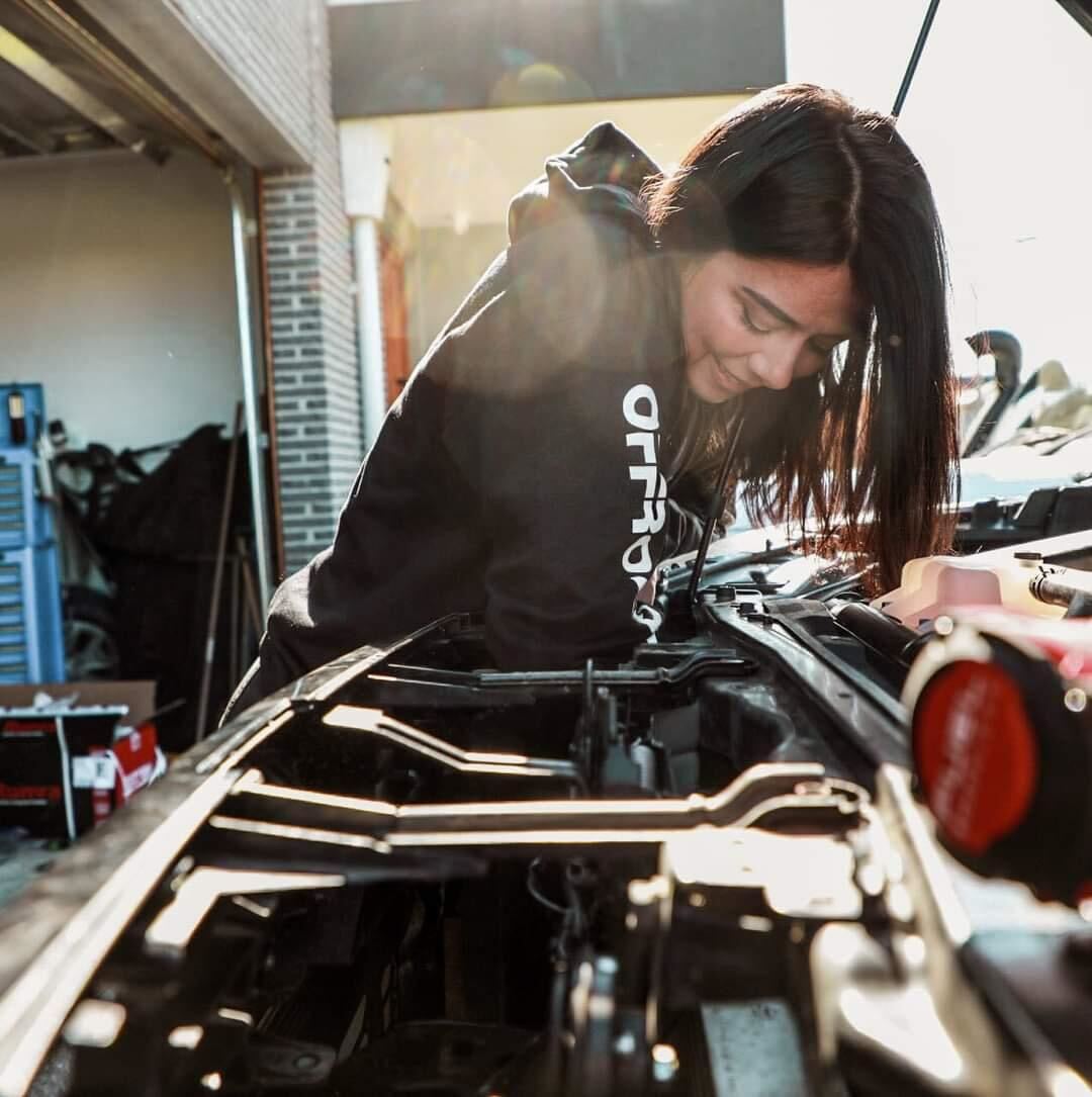 Close-up shot, Cara Tag Along Crew, wearing black hoodie, repairing her 4wd.